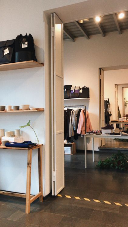 Moderne Modeboutique mit ausgewählter Kleidung, Taschen und reduziertem Interieur